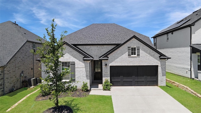 204 Savannah Ln, Oak Point, TX 75068 - french country style house with concrete driveway, a front yard, brick siding, and roof with shingles