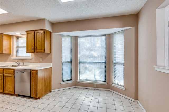 1608 Stroud Ln, Mesquite, TX 75150 - kitchen with dishwasher, light countertops, brown cabinets, light tile patterned floors, and a textured ceiling