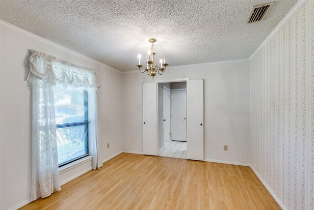 1608 Stroud Ln, Mesquite, TX 75150 - empty room featuring wood finished floors, a chandelier, crown molding, and a textured ceiling