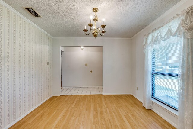 1608 Stroud Ln, Mesquite, TX 75150 - empty room featuring wood finished floors, a chandelier, ornamental molding, and a textured ceiling