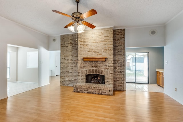 1608 Stroud Ln, Mesquite, TX 75150 - unfurnished living room with a textured ceiling, light wood finished floors, ceiling fan, crown molding, and a brick fireplace
