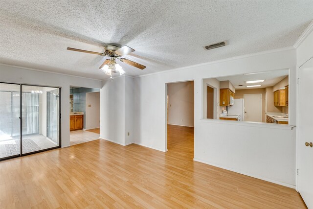 1608 Stroud Ln, Mesquite, TX 75150 - unfurnished living room with light wood-style floors, crown molding, ceiling fan, and a textured ceiling