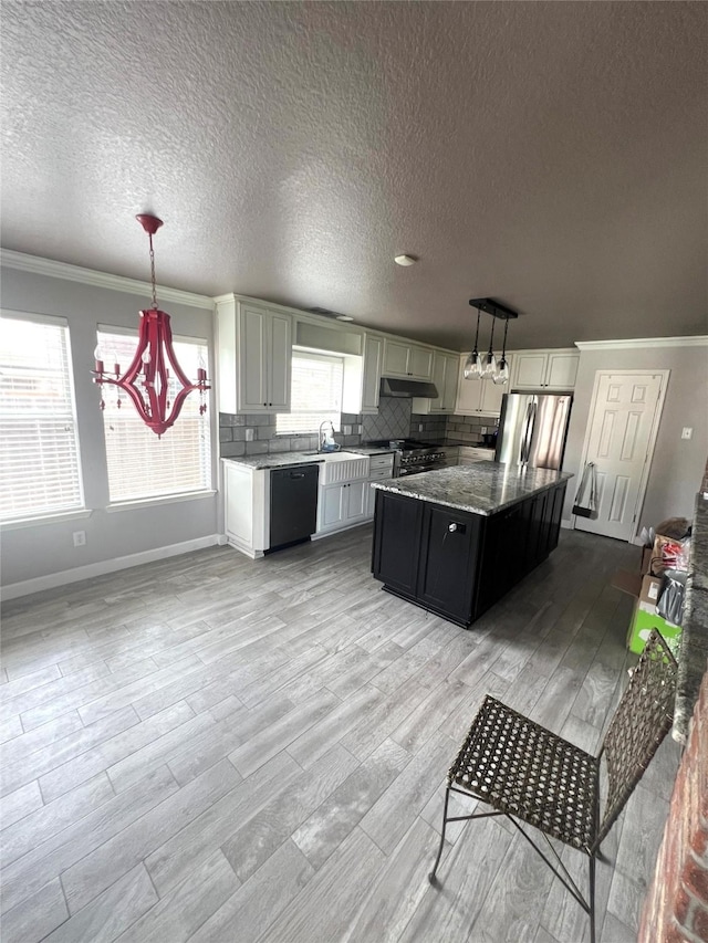5901 Westgate Dr, Fort Worth, TX 76179 - kitchen featuring black dishwasher, freestanding refrigerator, ornamental molding, a textured ceiling, and light wood-type flooring