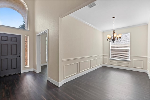 8516 Ontario Dr, Mckinney, TX 75072 - entrance foyer with a chandelier, crown molding, dark wood-style floors, and wainscoting