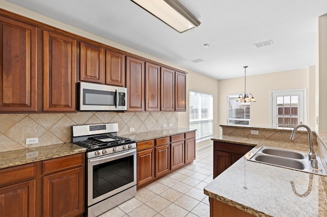 8516 Ontario Dr, Mckinney, TX 75072 - kitchen featuring stainless steel appliances, a chandelier, tasteful backsplash, light tile patterned floors, and pendant lighting