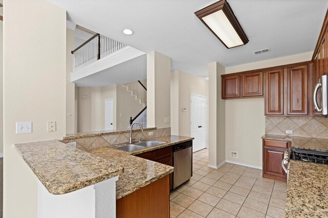 8516 Ontario Dr, Mckinney, TX 75072 - kitchen with appliances with stainless steel finishes, backsplash, a peninsula, light tile patterned floors, and light stone countertops