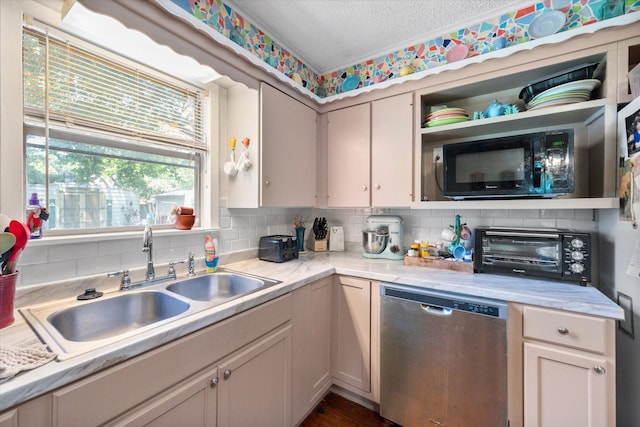 120 Woodland Ave, Corsicana, TX 75110 - kitchen with stainless steel dishwasher, black microwave, decorative backsplash, light countertops, and a textured ceiling