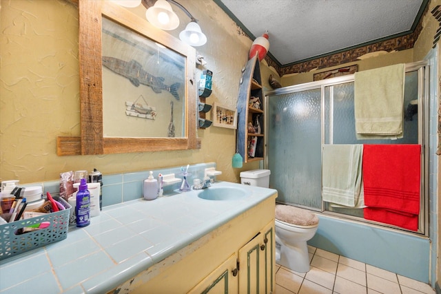 120 Woodland Ave, Corsicana, TX 75110 - full bath featuring vanity, a textured ceiling, bath / shower combo with glass door, tile patterned floors, and a textured wall