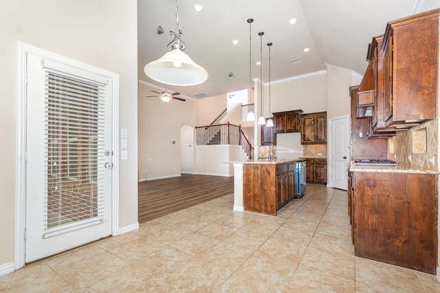 4600 Evenstar Way, Plano, TX 75074 - kitchen with high vaulted ceiling, a ceiling fan, a center island with sink, pendant lighting, and tasteful backsplash