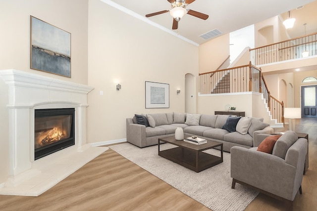 4600 Evenstar Way, Plano, TX 75074 - living room with arched walkways, a towering ceiling, stairs, a ceiling fan, and a fireplace