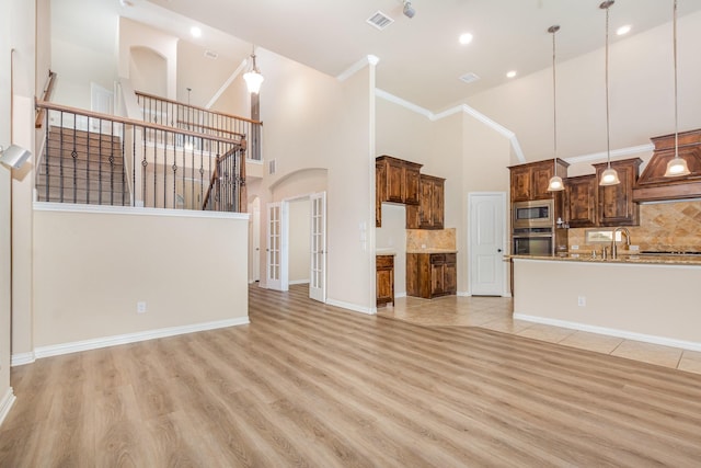 4600 Evenstar Way, Plano, TX 75074 - unfurnished living room featuring high vaulted ceiling, arched walkways, stairway, light wood-type flooring, and recessed lighting