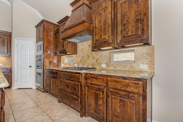 4600 Evenstar Way, Plano, TX 75074 - kitchen with appliances with stainless steel finishes, custom exhaust hood, light stone countertops, decorative backsplash, and light tile patterned floors