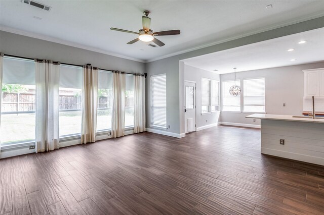 2400 Silverstone Ln, Mckinney, TX 75072 - unfurnished living room featuring ceiling fan, dark wood-type flooring, crown molding, a chandelier, and recessed lighting