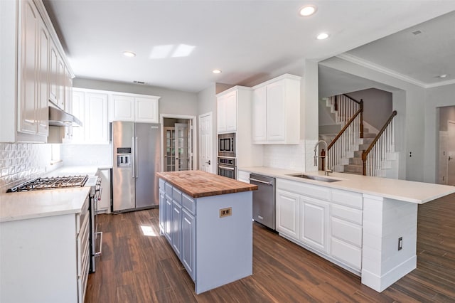 2400 Silverstone Ln, Mckinney, TX 75072 - kitchen with premium appliances, wooden counters, under cabinet range hood, white cabinets, and recessed lighting