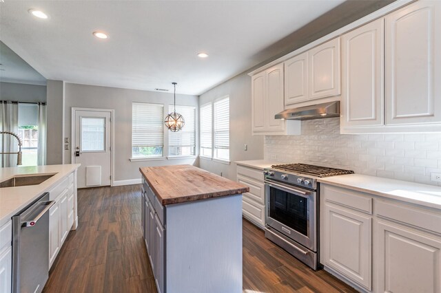 2400 Silverstone Ln, Mckinney, TX 75072 - kitchen with appliances with stainless steel finishes, wood counters, ventilation hood, a center island, and dark wood-style flooring
