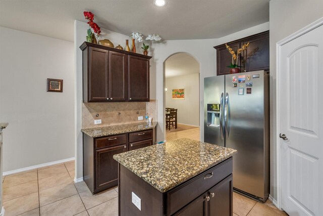 520 Rustic Oak Ln, Mckinney, TX 75072 - kitchen with stainless steel refrigerator with ice dispenser, arched walkways, light stone countertops, dark brown cabinets, and light tile patterned floors