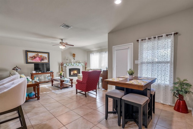 520 Rustic Oak Ln, Mckinney, TX 75072 - dining area featuring light tile patterned floors, a ceiling fan, a warm lit fireplace, and recessed lighting