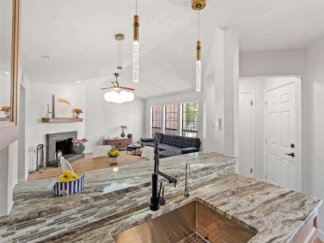 3101 Townbluff Dr Unit 922, Plano, TX 75075 - kitchen with open floor plan, a fireplace with raised hearth, light stone countertops, hanging light fixtures, and lofted ceiling