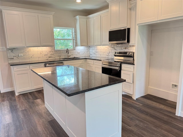 500 Ennis Scott St, Ferris, TX 75125 - kitchen with stainless steel appliances, white cabinetry, backsplash, dark wood-style floors, and recessed lighting