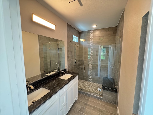 500 Ennis Scott St, Ferris, TX 75125 - full bathroom with a stall shower, double vanity, a textured ceiling, and wood finished floors