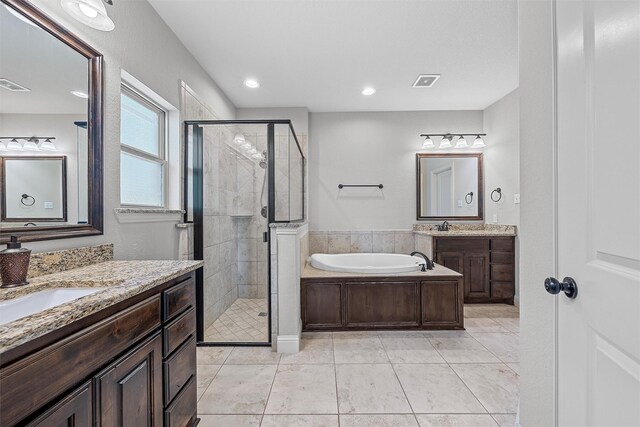2209 Therese Dr, Waco, TX 76712 - full bath with a shower stall, two vanities, a bath, tile patterned floors, and recessed lighting