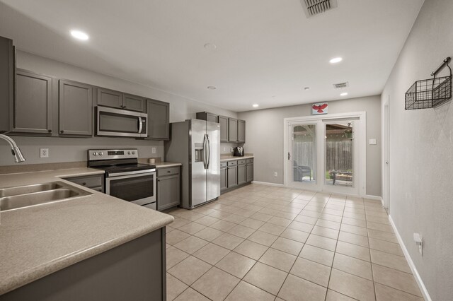 4505 Martingale View Ln, Fort Worth, TX 76244 - kitchen featuring appliances with stainless steel finishes, gray cabinets, light tile patterned floors, light countertops, and recessed lighting