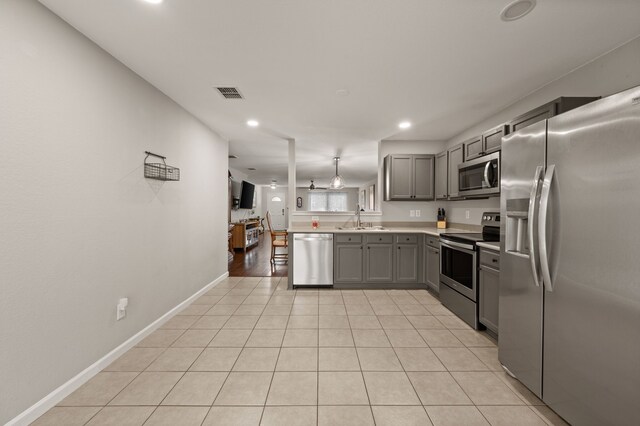 4505 Martingale View Ln, Fort Worth, TX 76244 - kitchen with appliances with stainless steel finishes, gray cabinetry, light countertops, recessed lighting, and a peninsula