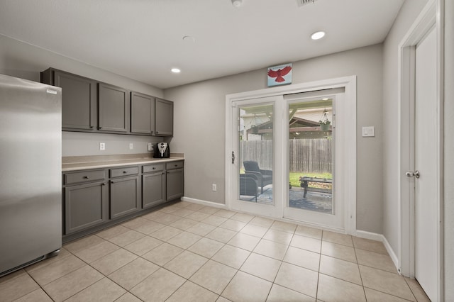 4505 Martingale View Ln, Fort Worth, TX 76244 - kitchen with freestanding refrigerator, gray cabinetry, light countertops, light tile patterned flooring, and recessed lighting