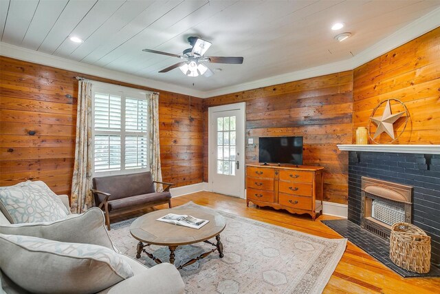 501 W Parks Ave, Waxahachie, TX 75165 - living area featuring crown molding, wood finished floors, ceiling fan, a brick fireplace, and wood walls