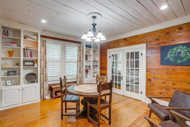 501 W Parks Ave, Waxahachie, TX 75165 - dining area with french doors, healthy amount of natural light, a chandelier, wood walls, and light wood-style floors