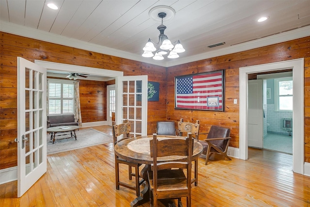 501 W Parks Ave, Waxahachie, TX 75165 - dining space featuring french doors, healthy amount of natural light, wooden walls, light wood-style flooring, and ornamental molding