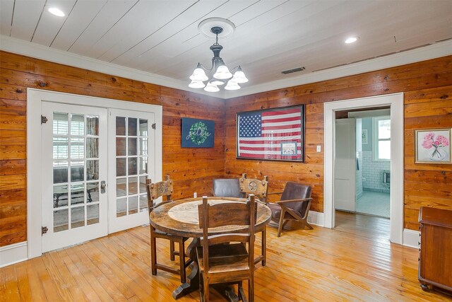501 W Parks Ave, Waxahachie, TX 75165 - dining space with french doors, a chandelier, wooden walls, light wood-style floors, and crown molding