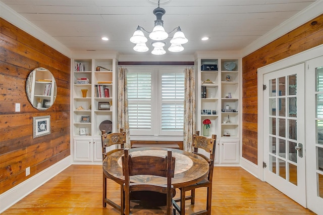 501 W Parks Ave, Waxahachie, TX 75165 - dining area with wood walls, a chandelier, light wood finished floors, plenty of natural light, and crown molding