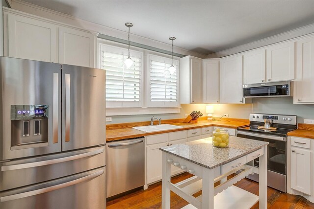 501 W Parks Ave, Waxahachie, TX 75165 - kitchen featuring stainless steel appliances, butcher block countertops, white cabinetry, and wood finished floors