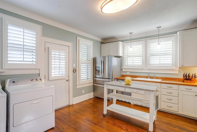 501 W Parks Ave, Waxahachie, TX 75165 - kitchen with washer / clothes dryer, stainless steel fridge, ornamental molding, decorative light fixtures, and dark wood-style flooring
