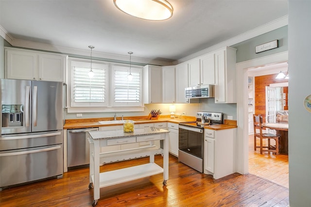 501 W Parks Ave, Waxahachie, TX 75165 - kitchen with stainless steel appliances, crown molding, dark wood-style flooring, wooden counters, and pendant lighting