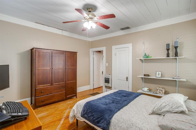 501 W Parks Ave, Waxahachie, TX 75165 - bedroom with heating unit, light wood finished floors, crown molding, and ceiling fan