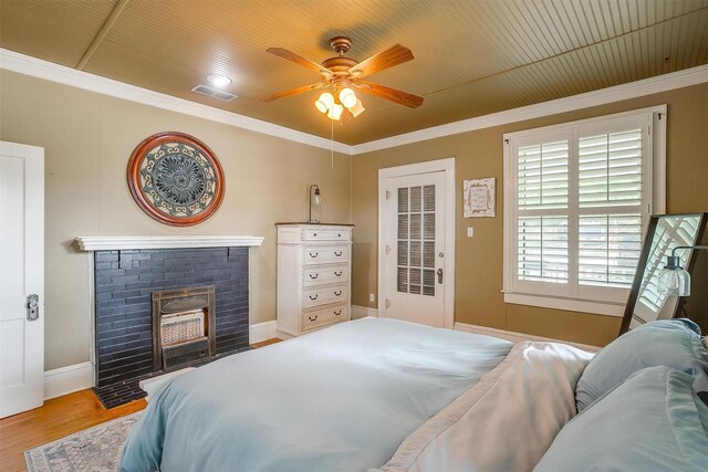 501 W Parks Ave, Waxahachie, TX 75165 - bedroom with crown molding, wood finished floors, a brick fireplace, and ceiling fan