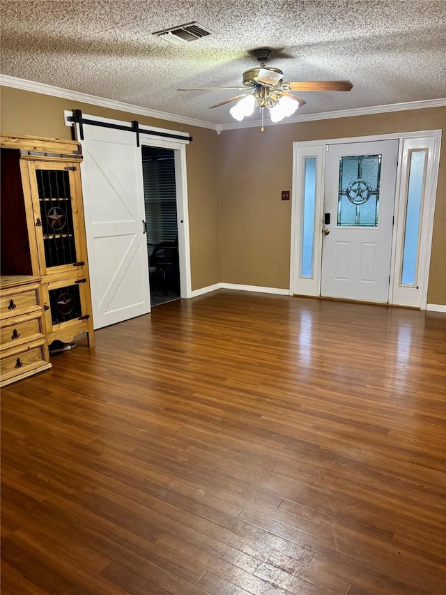 1006 S State Highway 14, Thornton, TX 76687 - foyer with a barn door, a ceiling fan, a textured ceiling, ornamental molding, and hardwood / wood-style flooring