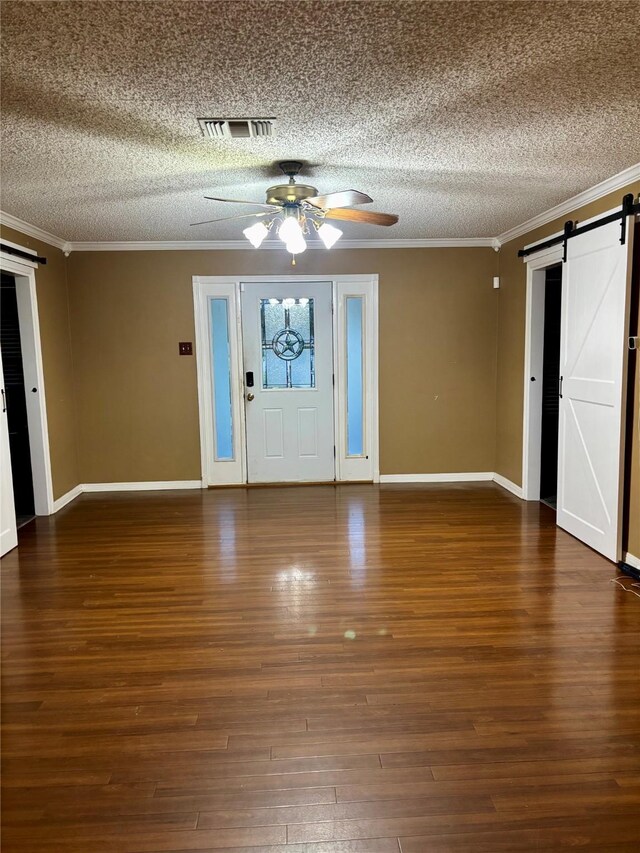 1006 S State Highway 14, Thornton, TX 76687 - foyer with a barn door, a textured ceiling, ceiling fan, ornamental molding, and wood finished floors