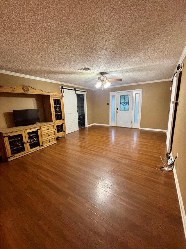 1006 S State Highway 14, Thornton, TX 76687 - unfurnished living room with a barn door, crown molding, wood finished floors, a textured ceiling, and a ceiling fan
