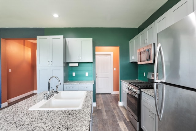 392 Calle Cedro Dr, Sherman, TX 75090 - kitchen with appliances with stainless steel finishes, dark wood-style floors, white cabinetry, tasteful backsplash, and recessed lighting