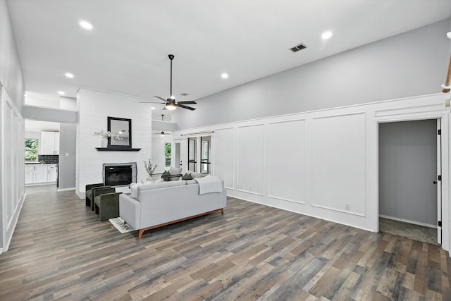 6604 Kingsferry Ct, Arlington, TX 76016 - living room featuring a decorative wall, a large fireplace, ceiling fan, wood finished floors, and recessed lighting