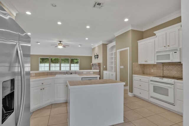 245 Harders Crossing Blvd, Shreveport, LA 71106 - kitchen featuring white appliances, a ceiling fan, light tile patterned floors, backsplash, and white cabinetry