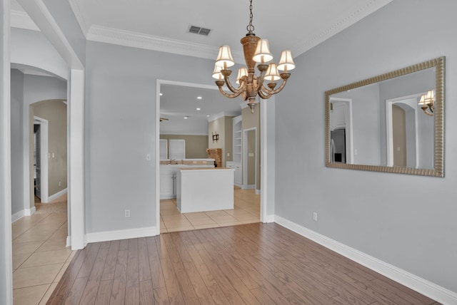 245 Harders Crossing Blvd, Shreveport, LA 71106 - unfurnished room featuring a chandelier, light wood-type flooring, arched walkways, and crown molding