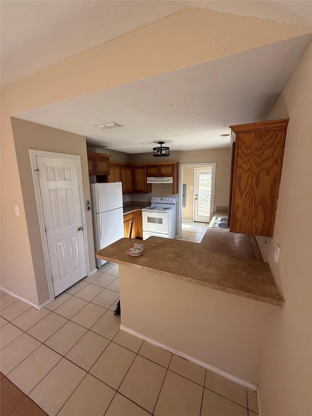 900 Reese Ln, Azle, TX 76020 - kitchen with white appliances, a peninsula, brown cabinets, under cabinet range hood, and light tile patterned flooring