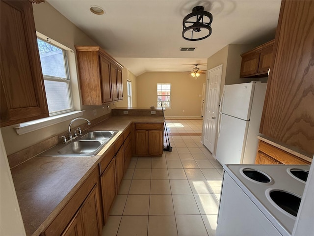900 Reese Ln, Azle, TX 76020 - kitchen featuring white appliances, brown cabinets, a peninsula, lofted ceiling, and ceiling fan