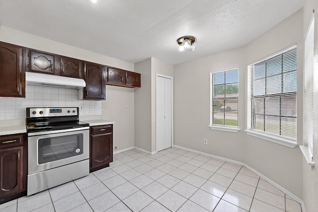 2411 Brookdale Dr, Arlington, TX 76014 - kitchen with electric stove, under cabinet range hood, light countertops, dark brown cabinetry, and decorative backsplash