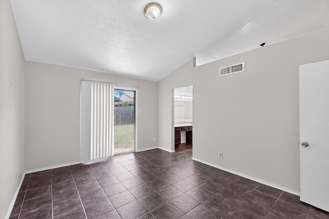 2411 Brookdale Dr, Arlington, TX 76014 - unfurnished room with vaulted ceiling and dark tile patterned floors