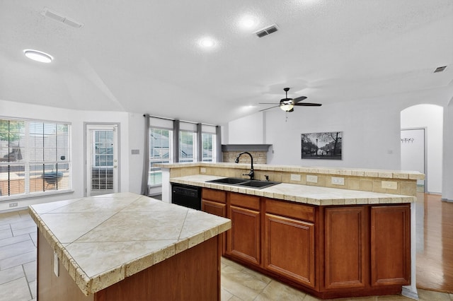 201 Settlers Glen Trl, Arlington, TX 76002 - kitchen with a kitchen island with sink, dishwasher, light countertops, a ceiling fan, and arched walkways